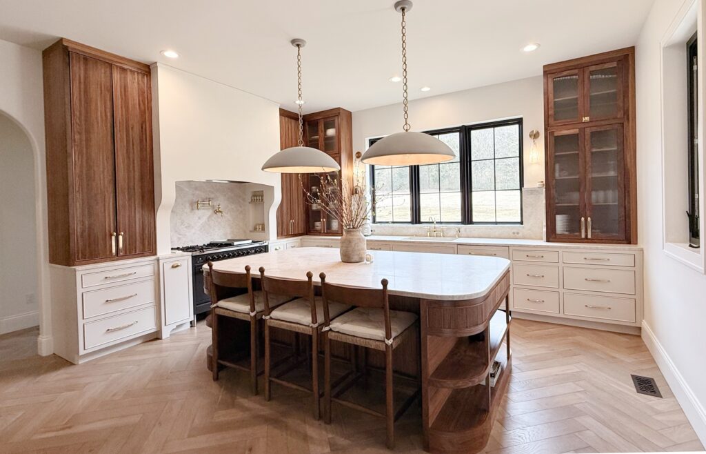 Two-tone kitchen with curved walnut island and cream painted cabinets