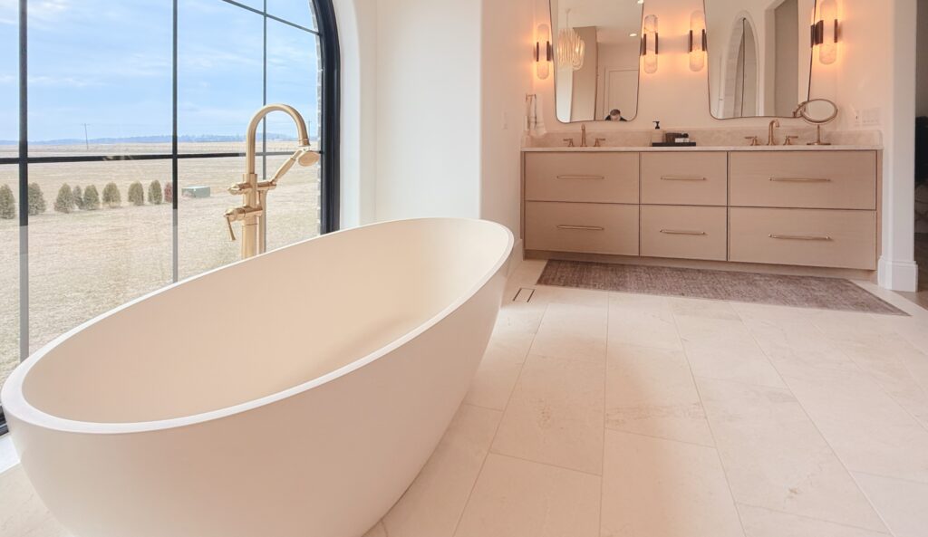 Primary bathroom with a floating white oak double vanity and brass pulls