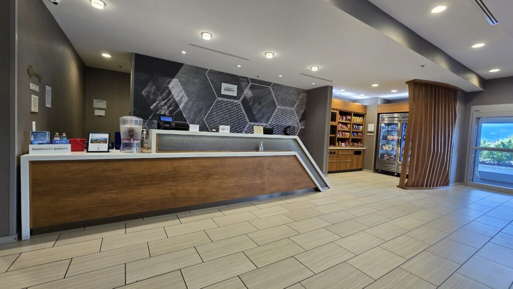 Hotel front desk in walnut panels with a white solid surface top
