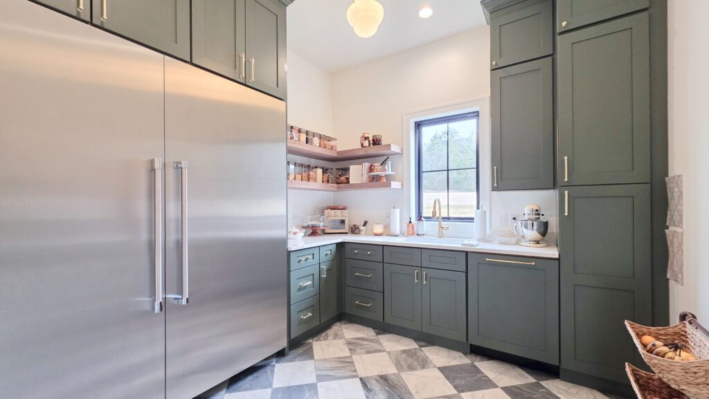 Butler's pantry with deep green shaker cabinets and floating wood shelves