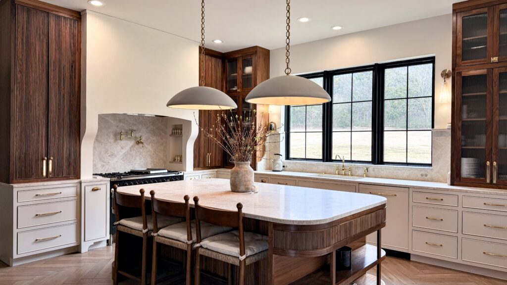 Two-tone kitchen with walnut tall cabinets, cream base cabinets, fluted walnut island and marble countertop